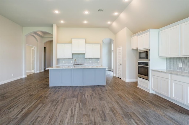 1639 Rosedale Dr, Missouri City, TX 77459 - kitchen featuring stainless steel oven, arched walkways, built in microwave, light countertops, and vaulted ceiling