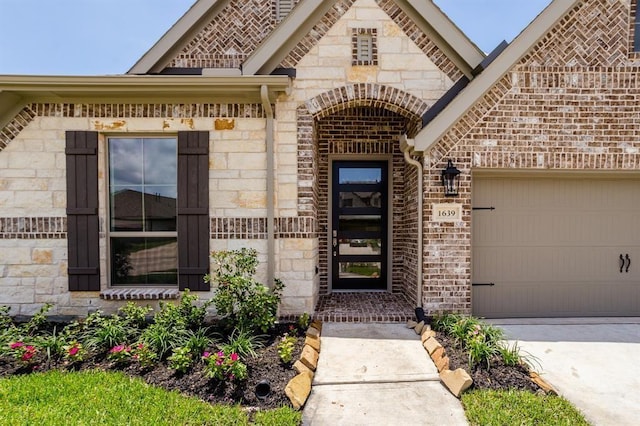 1639 Rosedale Dr, Missouri City, TX 77459 - property entrance featuring stone siding, a garage, driveway, and brick siding
