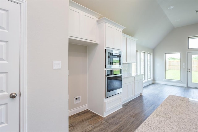 1639 Rosedale Dr, Missouri City, TX 77459 - kitchen featuring appliances with stainless steel finishes, wood finished floors, white cabinetry, lofted ceiling, and baseboards