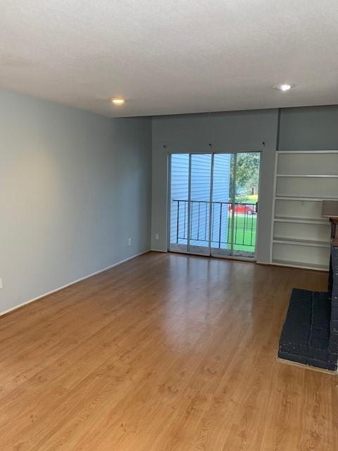 unfurnished living room with light wood-style floors, recessed lighting, and baseboards