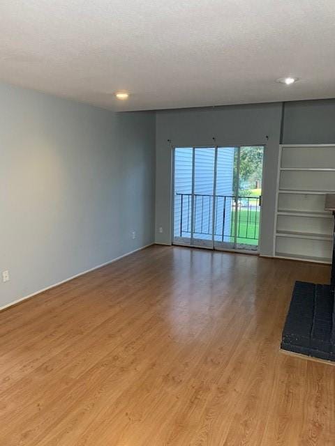 unfurnished room with wood finished floors, baseboards, recessed lighting, and a textured ceiling