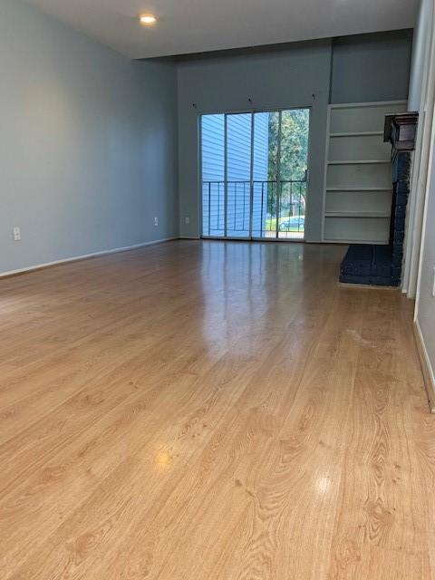 unfurnished living room with wood finished floors and baseboards