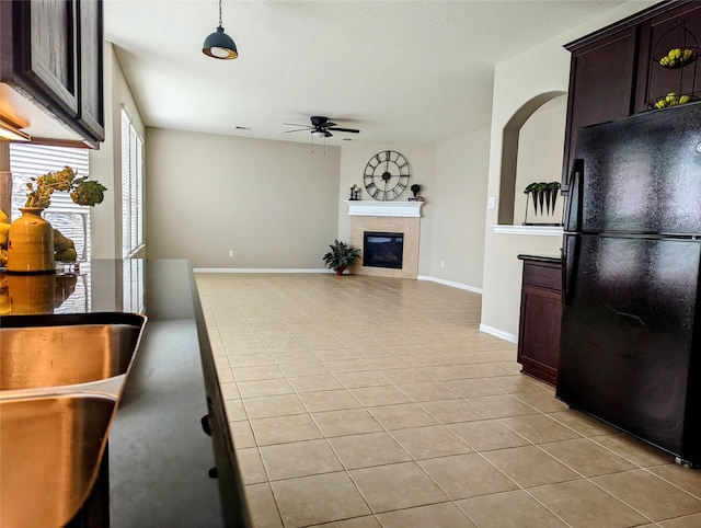10718 Wall Fern Way, Houston, TX 77034 - kitchen featuring freestanding refrigerator, ceiling fan, light tile patterned flooring, a fireplace, and dark brown cabinetry