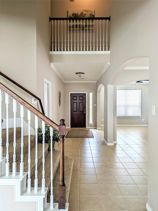 10718 Wall Fern Way, Houston, TX 77034 - foyer featuring arched walkways, crown molding, light tile patterned floors, a towering ceiling, and stairs