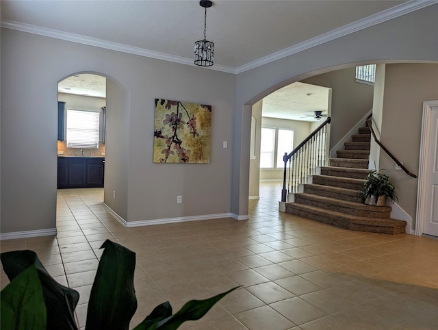 10718 Wall Fern Way, Houston, TX 77034 - entryway featuring light tile patterned flooring, plenty of natural light, arched walkways, crown molding, and stairway