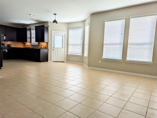 10718 Wall Fern Way, Houston, TX 77034 - kitchen with light tile patterned floors, open floor plan, dark cabinets, and baseboards