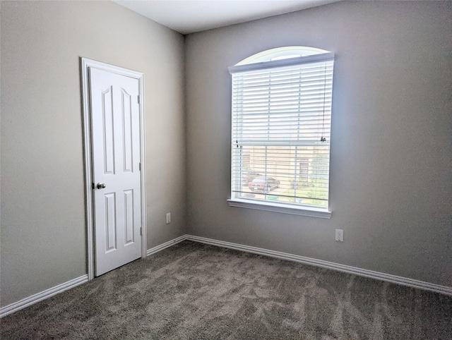 10718 Wall Fern Way, Houston, TX 77034 - empty room with healthy amount of natural light, dark colored carpet, and baseboards