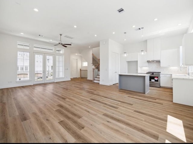 3507 Eaton Estates Ln, Houston, TX 77055 - unfurnished living room featuring recessed lighting, ceiling fan, light wood-style floors, healthy amount of natural light, and stairs