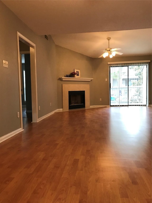 unfurnished living room featuring a ceiling fan, baseboards, wood finished floors, and a fireplace