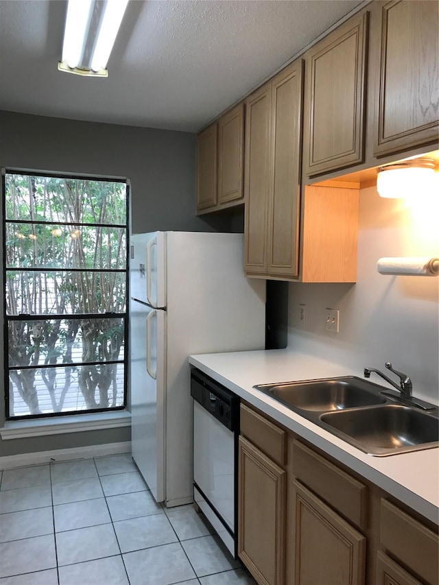 kitchen with dishwasher, a sink, light countertops, and light tile patterned floors
