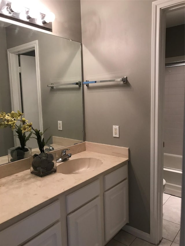 full bathroom with vanity, tile patterned floors, washtub / shower combination, and toilet