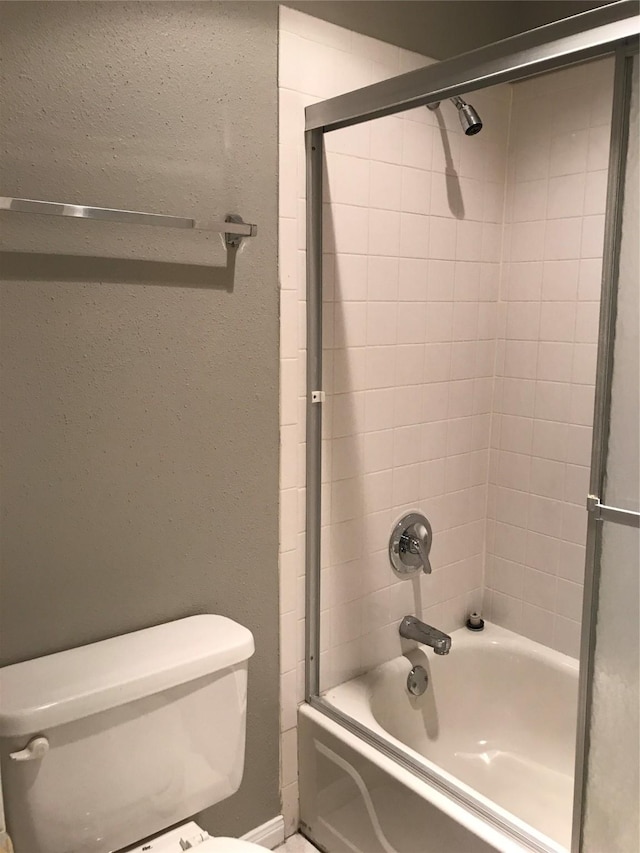 full bath featuring toilet and combined bath / shower with glass door