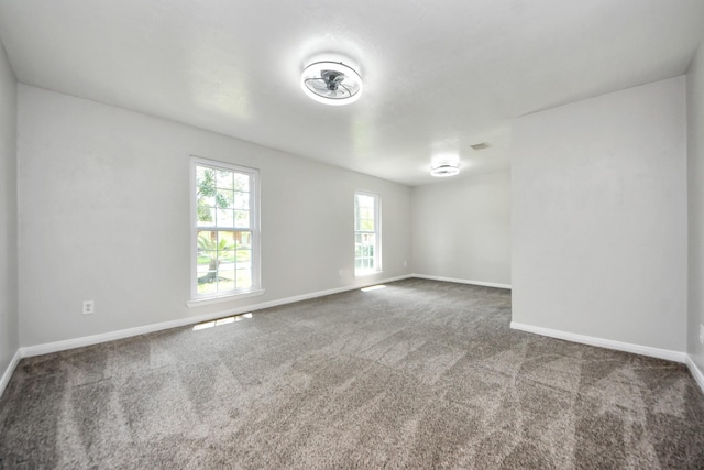carpeted empty room featuring baseboards