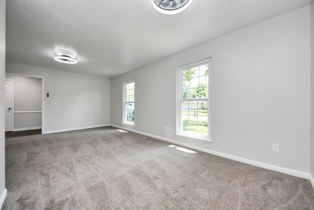 carpeted empty room with baseboards