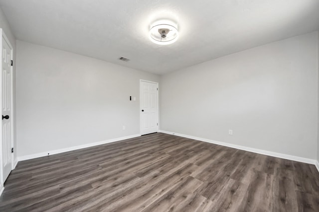 unfurnished room featuring dark wood-style floors and baseboards
