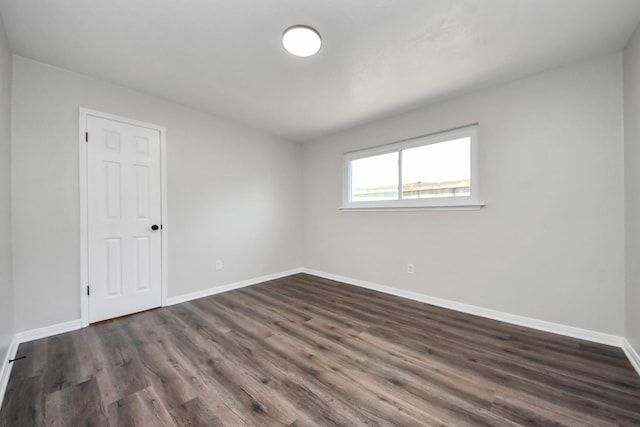 empty room with baseboards and dark wood finished floors