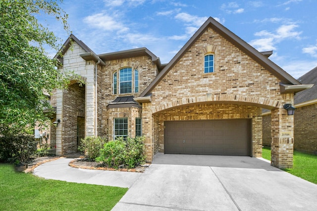 view of front of property featuring driveway, brick siding, and an attached garage