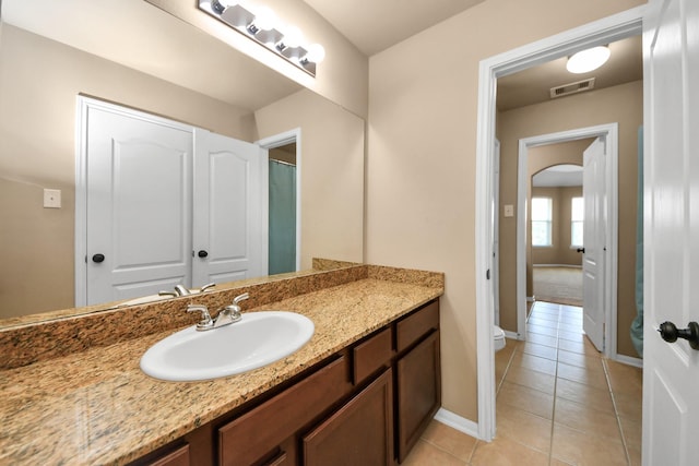 bathroom with tile patterned flooring, toilet, baseboards, and vanity