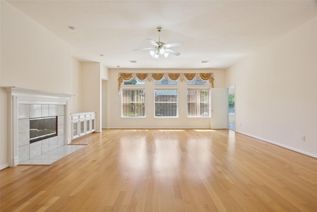 18415 Deer Crossing Dr, Humble, TX 77346 - unfurnished living room featuring a ceiling fan, light wood finished floors, a fireplace, and baseboards