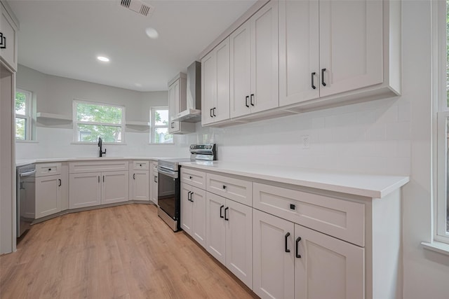 23331 Balthasar St, Spring, TX 77373 - kitchen with stainless steel appliances, wall chimney range hood, a sink, open shelves, and backsplash