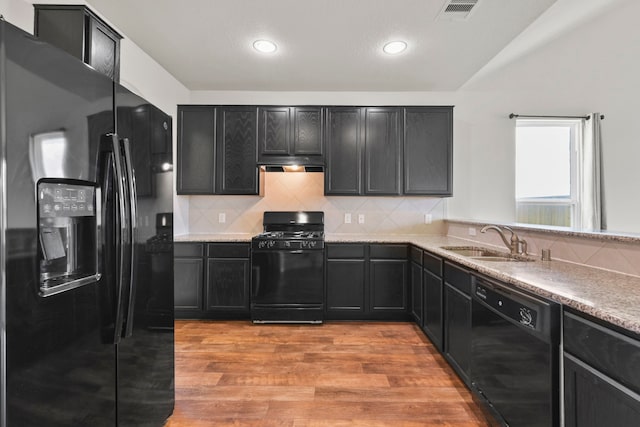 3011 Tandem Ct, Rosenberg, TX 77471 - kitchen with black appliances, a sink, light wood-style floors, decorative backsplash, and recessed lighting