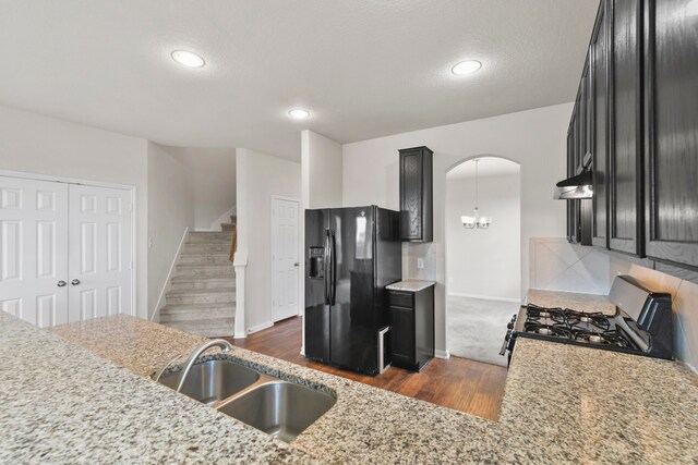 3011 Tandem Ct, Rosenberg, TX 77471 - kitchen featuring black refrigerator with ice dispenser, a sink, range with gas cooktop, dark wood finished floors, and baseboards