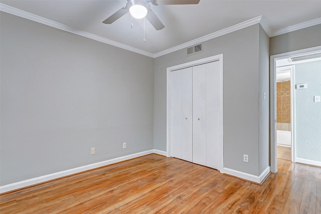 unfurnished bedroom with light wood-type flooring, a closet, crown molding, baseboards, and ceiling fan