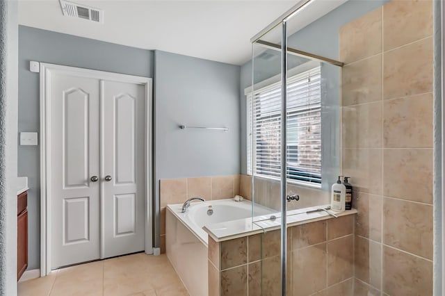 full bathroom featuring a garden tub, tile patterned flooring, and tiled shower