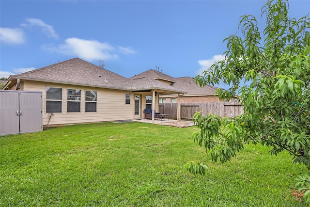back of property featuring a patio, an outbuilding, a shingled roof, and a storage unit