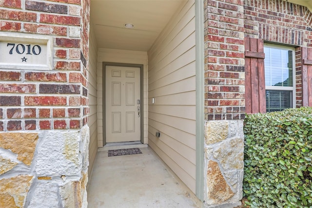 view of exterior entry featuring brick siding