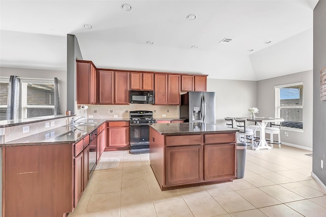 kitchen with black appliances, a sink, lofted ceiling, a center island, and light tile patterned floors