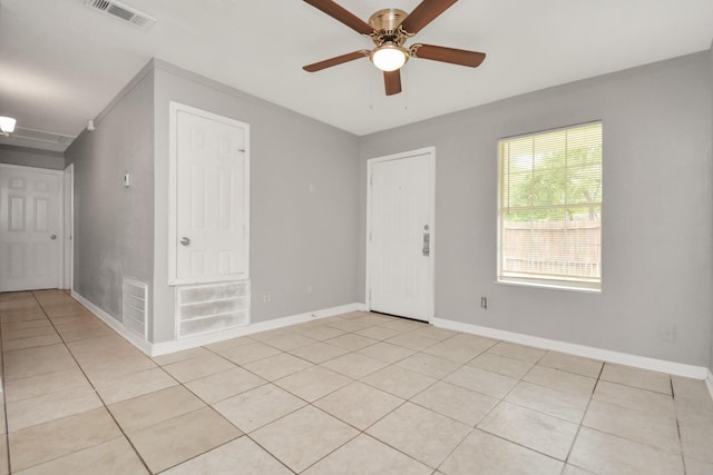 unfurnished room with light tile patterned floors, a ceiling fan, and baseboards