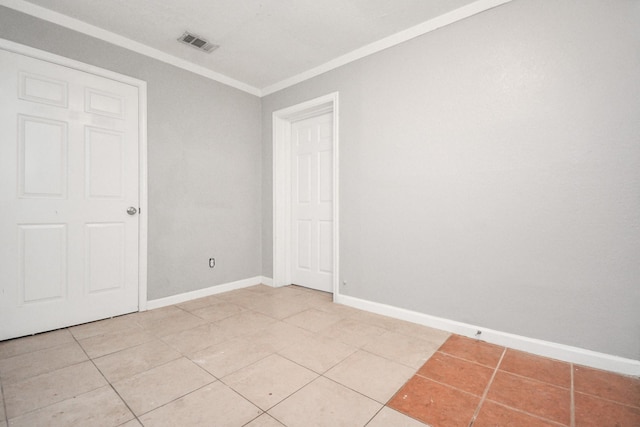 unfurnished bedroom with ornamental molding, light tile patterned floors, and baseboards
