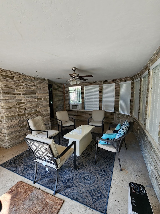 living area featuring ceiling fan, speckled floor, and cooling unit