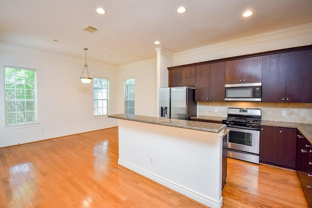 2612 Starboard Point Dr, Houston, TX 77054 - kitchen featuring appliances with stainless steel finishes, a center island, plenty of natural light, light wood-style floors, and crown molding