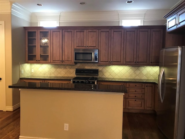 1428 Wichita St, Houston, TX 77004 - kitchen with appliances with stainless steel finishes, dark wood-style flooring, glass insert cabinets, dark stone counters, and crown molding