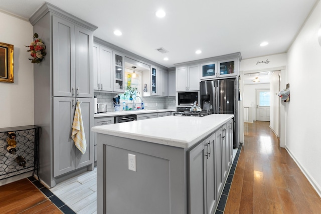 2120 73rd St, Galveston, TX 77551 - kitchen with gray cabinetry, built in microwave, light wood-style flooring, tasteful backsplash, and recessed lighting