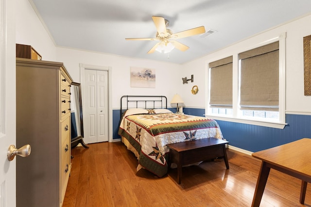 2120 73rd St, Galveston, TX 77551 - bedroom with wood finished floors, a wainscoted wall, ceiling fan, and baseboards