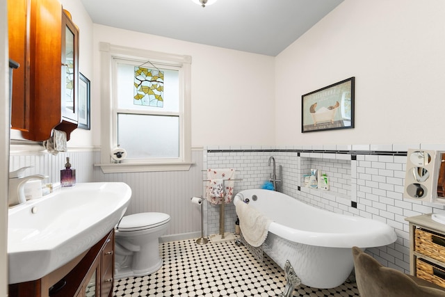 2120 73rd St, Galveston, TX 77551 - full bath with a wainscoted wall, vanity, a freestanding bath, and toilet