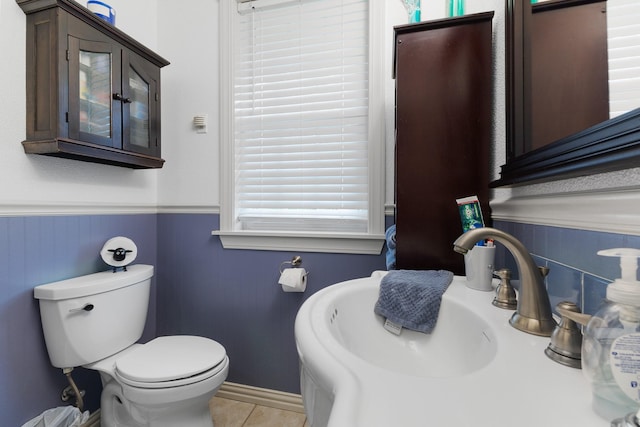 2120 73rd St, Galveston, TX 77551 - bathroom featuring wainscoting, a sink, toilet, tile patterned flooring, and baseboards