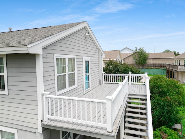 2120 73rd St, Galveston, TX 77551 - view of side of property with stairs, a wooden deck, and roof with shingles