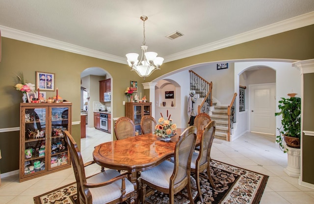 11939 Galentine Pt, Cypress, TX 77429 - dining space with light tile patterned flooring, ornamental molding, a chandelier, baseboards, and arched walkways