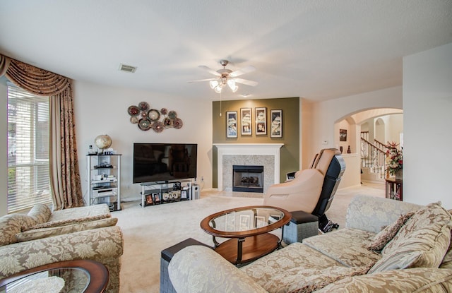 11939 Galentine Pt, Cypress, TX 77429 - living room with carpet floors, arched walkways, ceiling fan, and a fireplace