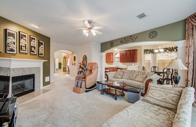 11939 Galentine Pt, Cypress, TX 77429 - living area featuring arched walkways, ceiling fan, light carpet, a chandelier, and a fireplace