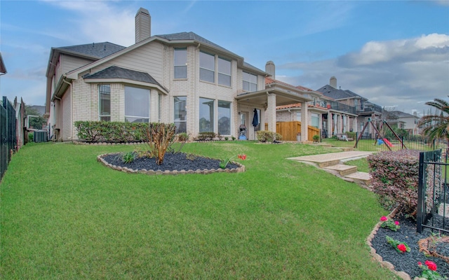 11939 Galentine Pt, Cypress, TX 77429 - rear view of property with central air condition unit, a playground, a chimney, brick siding, and a shingled roof