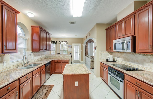 11939 Galentine Pt, Cypress, TX 77429 - kitchen with appliances with stainless steel finishes, a sink, backsplash, a center island, and a textured ceiling
