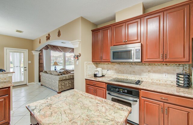 11939 Galentine Pt, Cypress, TX 77429 - kitchen with stainless steel appliances, open floor plan, decorative backsplash, and light tile patterned flooring