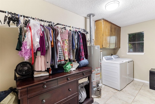 1448 Camellia Dr, Sweeny, TX 77480 - laundry room with washer and dryer, gas water heater, cabinet space, a textured ceiling, and light tile patterned flooring