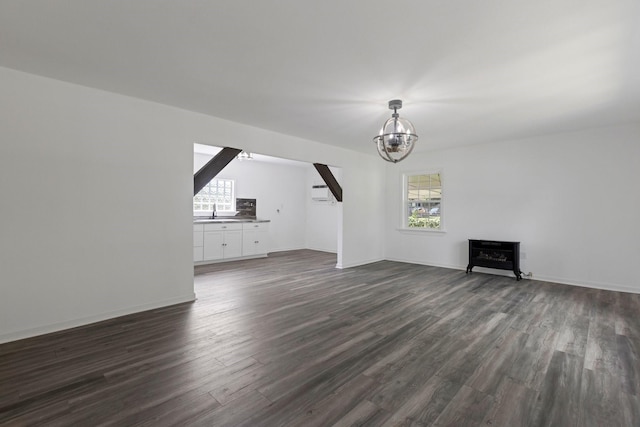 639 Manor St, Houston, TX 77015 - unfurnished living room with a chandelier, dark wood-style flooring, a sink, and baseboards