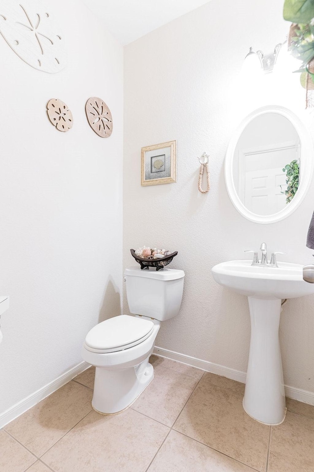 bathroom with tile patterned flooring, toilet, and baseboards